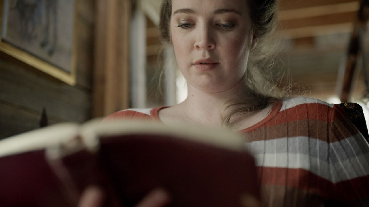 Une femme lisant le Livre de Mormon sur un canapé